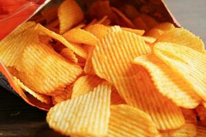 croustilles de pommes de terre dans un sac ouvert, délicieux assaisonnement pour barbecue épicé pour les frites, collations frites en tranches fines de restauration rapide. photo