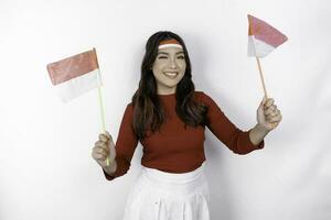 excité Jeune asiatique femme célébrer indonésien indépendance journée en portant le indonésien drapeau isolé sur blanc Contexte photo