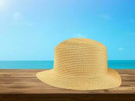 paille chapeau pose sur en bois table avec ciel et mer Contexte. photo