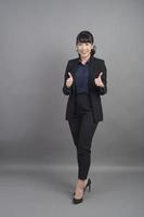 femme d'affaires souriante en blazer sur fond gris photo