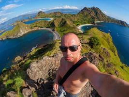 un homme de race blanche fait un selfie sur l'île de padar à flores en indonésie photo