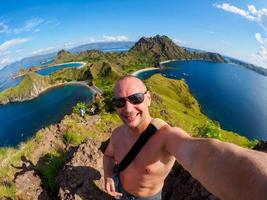 un homme de race blanche fait un selfie sur l'île de padar à flores en indonésie