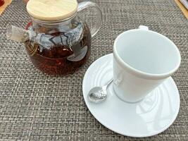 théière avec thé et une tasse sur le table photo