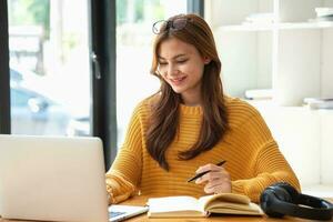 content Latin fille Université étudiant en train de regarder distance en ligne apprentissage classe, éloigné Université séminaire en ligne ou ayant parler sur portable vidéo appel et utilisation carnet à virtuel réunion séminaire à Accueil ou Campus photo