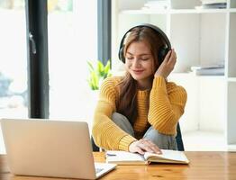 content Latin fille Université étudiant en train de regarder distance en ligne apprentissage classe, éloigné Université séminaire en ligne ou ayant parler sur portable vidéo appel et utilisation carnet à virtuel réunion séminaire à Accueil ou Campus photo