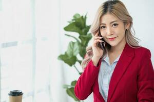 consultant, asiatique femme d'affaires travail sur le téléphone qui discussion financier travail et commercialisation affaires plan à augmenter entreprise bénéfices, prêt à utilisation ordinateur et commercialisation Planification documents. photo