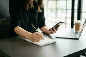 femme d'affaires main travail avec Nouveau moderne ordinateur et l'écriture sur le bloc-notes stratégie diagramme comme concept photo