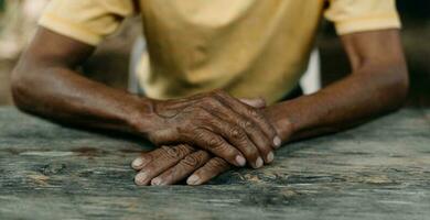 gros plan des mains ridées des hommes, le vieil homme porte sur la table en bois photo