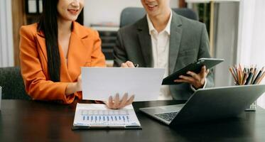 femme d'affaires et équipe en cours d'analyse financier déclaration la finance tâche. avec intelligent téléphone et portable et tablette. richesse la gestion concept photo