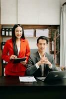 deux asiatique femme d'affaires discuter investissement projet travail et Planification stratégie avec tablette portable ordinateur dans bureau. photo