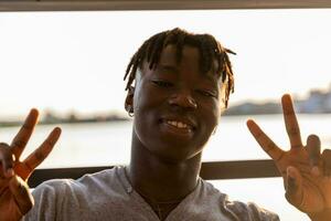 portrait de Jeune Beau africain américain homme séance sur bateau voile pendant été vacances photo