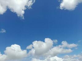 nuages blancs dans le ciel bleu. beau fond bleu clair. peu nuageux, beau temps. nuages bouclés par une journée ensoleillée. photo