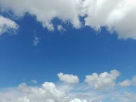 nuages blancs dans le ciel bleu. beau fond bleu clair. peu nuageux, beau temps. nuages bouclés par une journée ensoleillée. photo