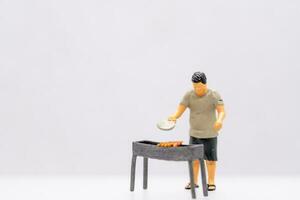 miniature gens Jeune homme grillage un barbecue photo