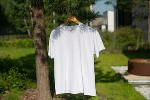 blanc T-shirt pendaison sur une cintre, disposition photo