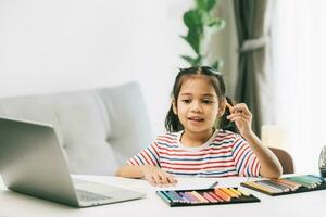 mignonne asiatique enfant fille dessin avec Couleur des crayons à Accueil photo