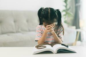 peu fille prier dans le matin.petit asiatique fille main prier, mains plié dans prière concept pour foi, spiritualité et religion. photo