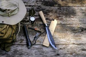 couteau sac à dos avec équipement pour survie dans le forêt sur le vieux en bois Contexte photo