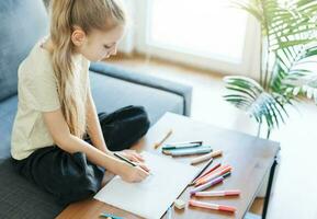 enfant fille dessin avec coloré des crayons photo