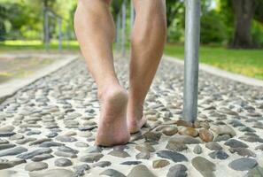 pieds nus vieux homme faire un pas sur pierres, pied réflexologie à le parc.concept de pied massage pour augmenter du sang circulation dans personnes âgées,secours pour fatigué et endolori pieds photo