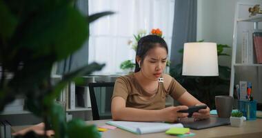 Jeune asiatique femme avec écouteur en jouant une Jeu sur mobile téléphone photo