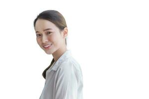 Jeune magnifique asiatique femme dans blanc chemise est souriant et permanent tandis que isolé sur blanc Contexte. photo