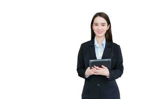 professionnel Jeune asiatique travail femme dans affaires noir costume détient tablette dans sa mains et sur de soi sourit tandis que isolé sur blanc Contexte photo