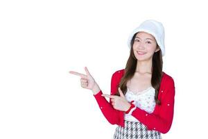 magnifique asiatique femme qui porte rouge manteau et blanc chapeau comme santy fille actes sa main à présent quelque chose isolé sur blanc Contexte. photo