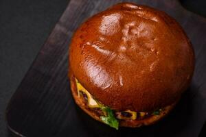 Burger avec juteux du boeuf escalope, fromage, tomates, sel, épices et herbes photo