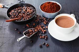 grains de café torréfiés avec de la poudre de café et des tasses à café. photo