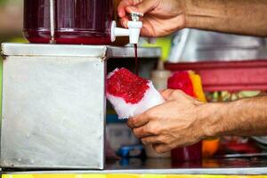 rue vendeur dans le ville de cali dans Colombie en train de préparer et vente une traditionnel sucré l'eau la glace appelé cholado photo