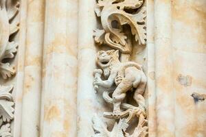 dragon en mangeant la glace crème sculpté sur le façade de le historique salmanque cathédrale photo