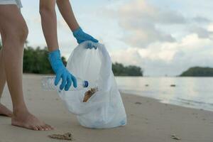 enregistrer océan. bénévole choisir en haut poubelle des ordures à le plage et Plastique bouteilles sont difficile décomposer prévenir nuire aquatique vie. Terre, environnement, écologisation planète, réduire global échauffement, enregistrer monde photo