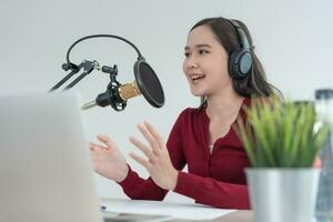 Asie femme est Parlant à encourager sur une radio diffusion gare. magnifique femelle organisé le radio programme. radio, podcast, vivre fumant, divertissement, écouter, technologie, musique, orateur photo