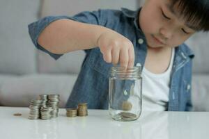 économiser de l'argent. les enfants mettent des pièces pour économiser. richesse, finance, assurance, investissement, éducation, avenir, planifier la vie, apprendre, banque, famille, santé, assurance maladie et accident. photo