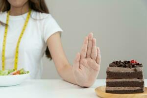 beauté corps féminin mince confondre le gâteau au chocolat. une femme au restaurant atteint son objectif de perte de poids pour une vie saine, folle de minceur, de taille fine, de nutritionniste. régime alimentaire, forme du corps. photo