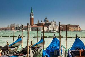 traditionnel vénitien gondoles à le grandiose canal dans de face de le magnifique Basilique di san Giorgio maggiore photo