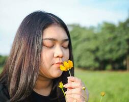 portrait de jardinier Jeune femme asiatique joufflu mignonne magnifique un la personne à la recherche main en portant soins pour les plantes feuilles jardin parc beauté fleurs soir lumière du soleil Frais souriant content se détendre été journée photo