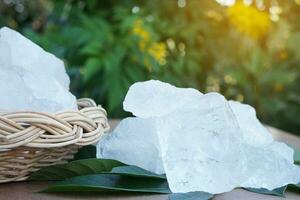 blanc cristal alun pierre ou potassium alun sur vert feuilles. chimique composé. utile pour beauté et spa traitement. utilisation à traiter corps odeur en dessous de le aisselles comme déodorant photo