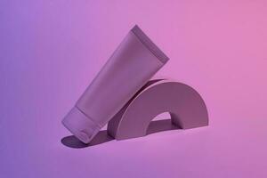 blanc cosmétique tube maquette. Plastique emballage pour cosmétologie crème produit sur une blanc podium sur néon bleu et rose Contexte. soin de la peau concept photo