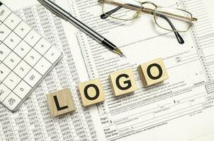 logo mot sur en bois blocs et stylo, calculatrice avec des lunettes photo