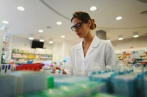 femme travail dans le pharmacie regards pour le médicament photo