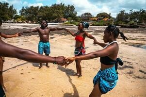 kenyan gens Danse sur le plage avec typique local vêtements photo