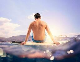 homme à le mer prêt à le surf avec planche de surf photo