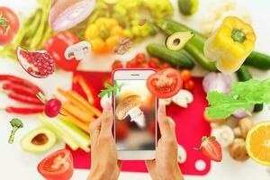 cuisinier suit une recette de des légumes de le téléphone intelligent photo
