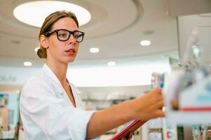 femme travail dans le pharmacie regards pour le médicament photo