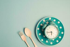 un alarme l'horloge sur un vide assiette et coutellerie ensemble photo