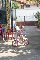 petite fille conduit son vélo dans l'arrière-cour