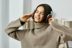 étudiant femme intérieur caucasien écouteurs content Jeune écouteurs Ecoutez Accueil la musique photo