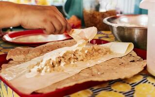 mains fabrication nicaraguayen quesillo. central américain nourriture le quesillo, vue de le traditionnel quesillo avec mariné oignon, préparation de le traditionnel nicaraguayen quesillo photo